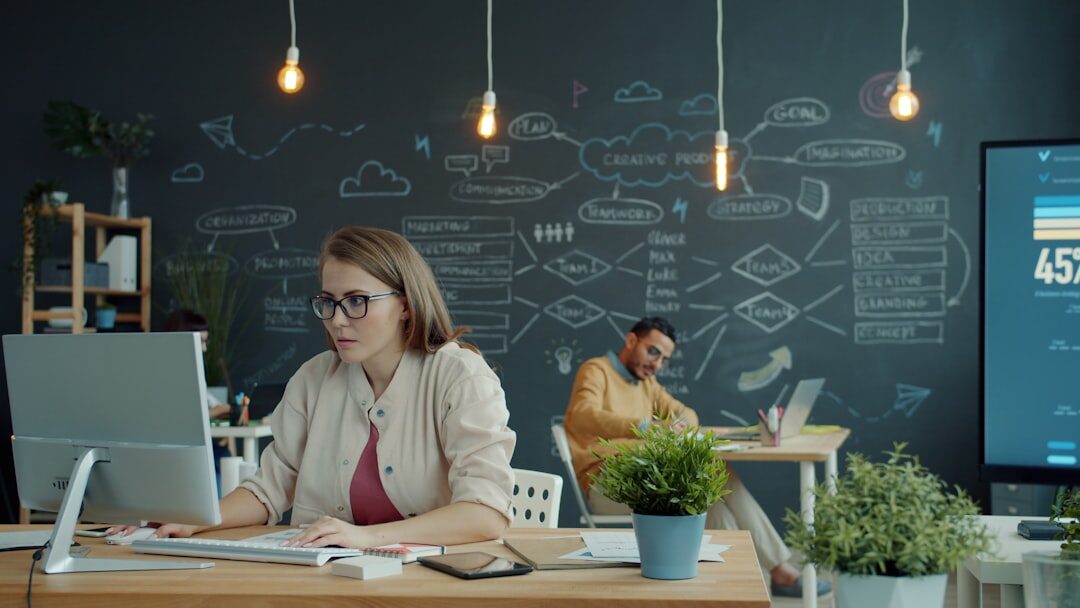 Newsroom with journalists working at computers in a modern office